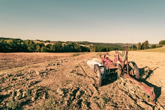 Closeup of a plow standing on a hill in the idyllic Tuscan countryside, Tuscany, Italy.