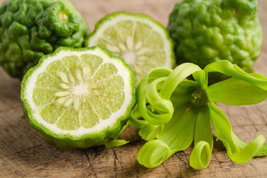 Fresh bergamot fruit with cut in half on wooden background.