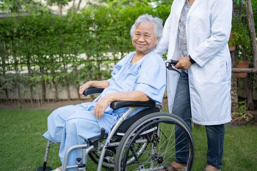 Doctor help and care Asian senior or elderly old lady woman patient sitting on wheelchair at park in nursing hospital ward, healthy strong medical concept.