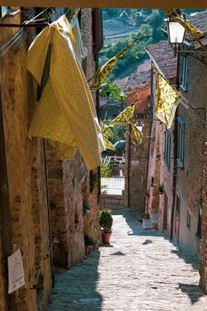 View of a characteristic street in the town of San Casciano dei Bagni. Note the beautiful medieval flags. Siena, Tuscany, Italy.