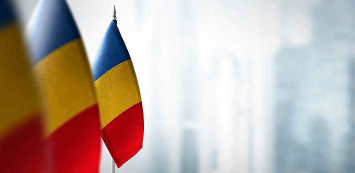 Small flags of France on a blurry background of the city.