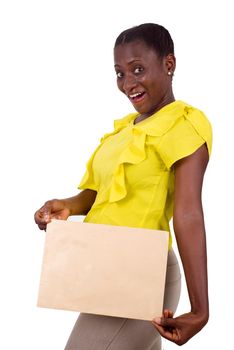 young girl standing in yellow camisole holding envelope in hand and smiles at the camera.