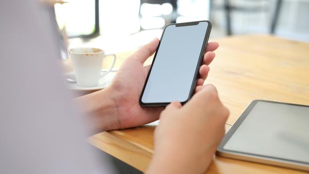 Close up of man hand holding smart phone. Blank screen mockup for graphics display montage.