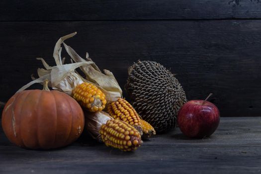 Autumn harvest composition with corn squash sunflowers and apples on rustic background