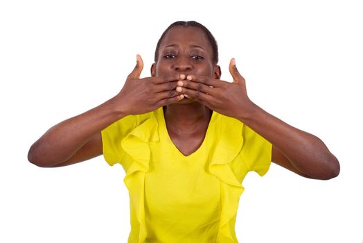 young girl standing in yellow tank looking at the camera with her hands on her mouth.
