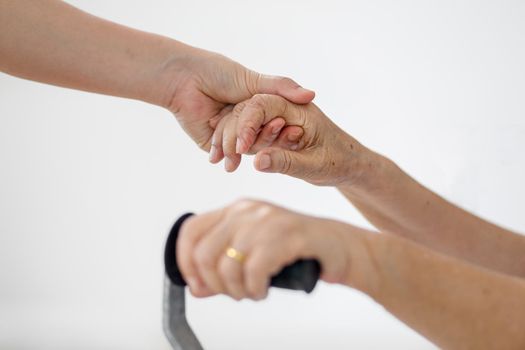 Elderly asian woman using a cane at home with caregiver take care