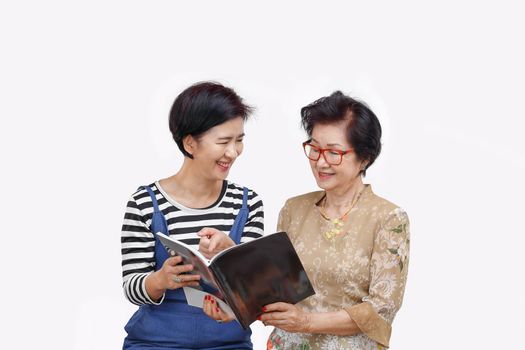 Senior woman reading a magazine with her daughter