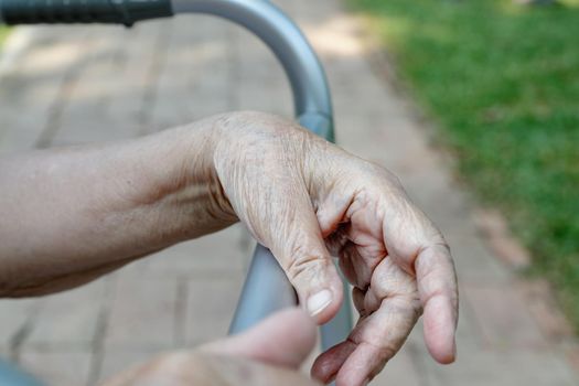 Elderly woman using a walker in backyard