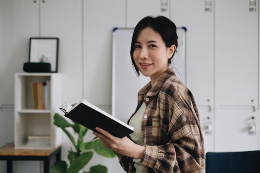 Portrait of cheerful asian woman with casual life on desk in home office. Concept of young business people working at home.