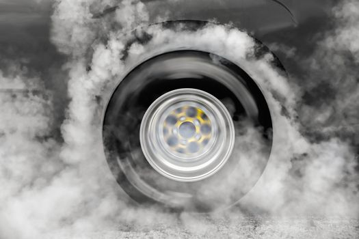 Drag racing car burns rubber off its tires in preparation for the race