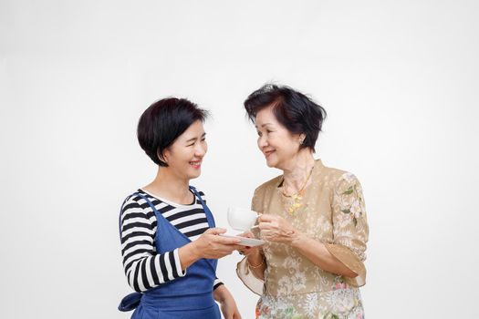 Senior woman drinking tea with her daughter take care, isolated on white background