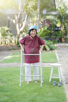 Elderly woman walking barefoot therapy on grass in backyard.