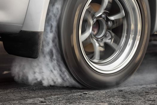 Drag racing car burns rubber off its tires in preparation for the race