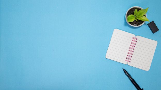 Education or back to school Concept. Top view of Colorful school supplies with books, color pencils, calculator, pen cutter clips and apple on blue pastel background. Flat lay.