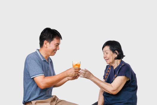 Elderly woman getting a glass of iced tea from son