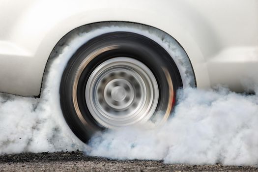 Drag racing car burns rubber off its tires in preparation for the race