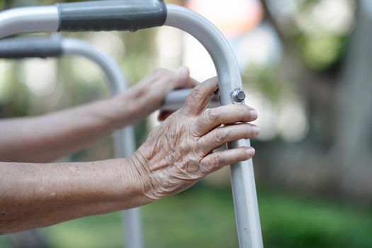 Elderly woman using a walker in backyard