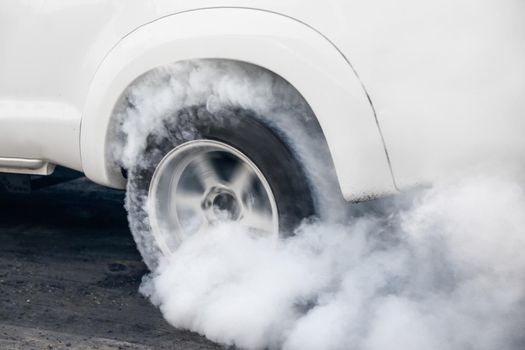 Drag racing car burns rubber off its tires in preparation for the race