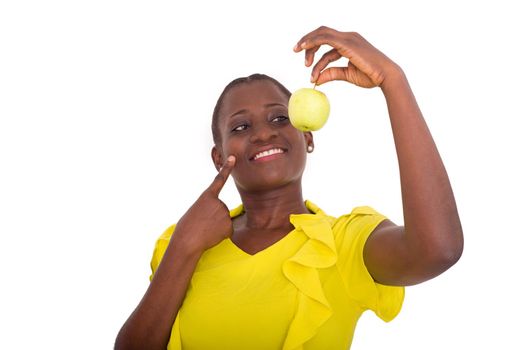 young girl standing in yellow tank watching an apple smiling camera.