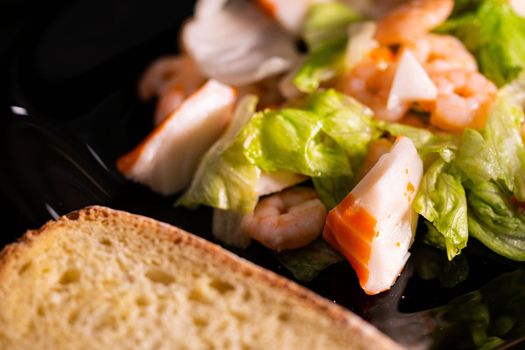 seafood salad composition with shrimps and surimi with cutlery and glass of white wine and lemons