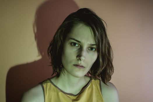 Dark portrait of serious young woman. Green light