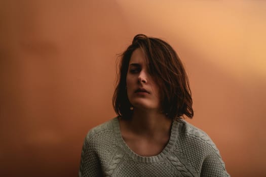 Young woman looks to the side. Dark portrait.