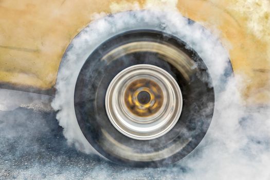 Drag racing car burns rubber off its tires in preparation for the race