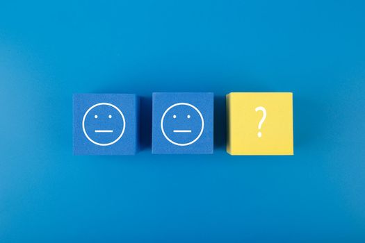 Blue and yellow cubes with emoji as metaphor for searching treatment and solution for mental or psychological problems. Minimal modern mental health concept in blue colors