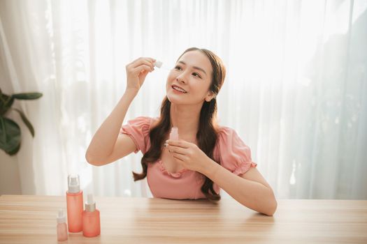 Beauty blogging. Makeup and face care tutorial. Young attractive woman holds in her hands a beauty product