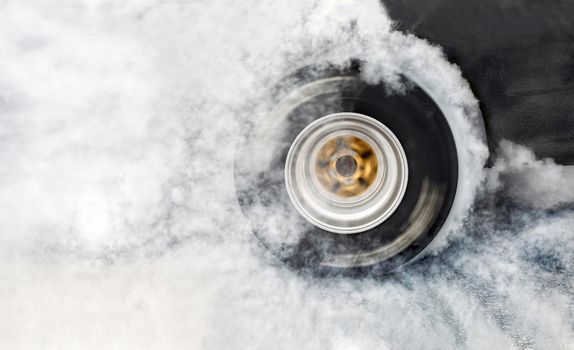 Drag racing car burns rubber off its tires in preparation for the race