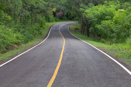 Curve way of asphalt road through the tropical forest in northern Thailand.