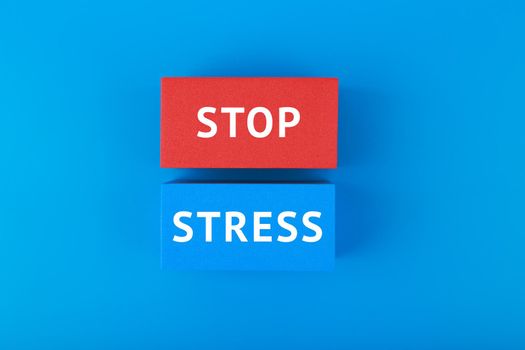 Stop stress written on blue and red rectangles against dark blue background. Concept of mental health, stress, anxiety and negative emotions prevention and treatment