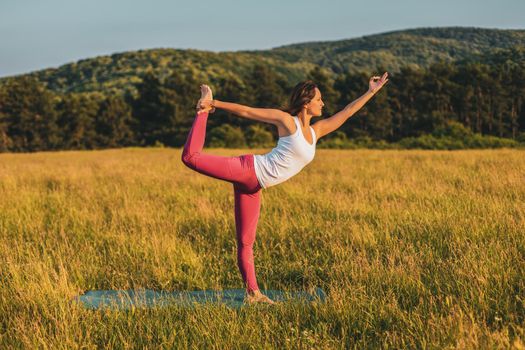 Beautiful woman doing yoga in the nature,Natarajasana / Shiva posture.