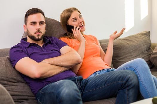Angry wife and husband are having conflict because wife is using phone too much.