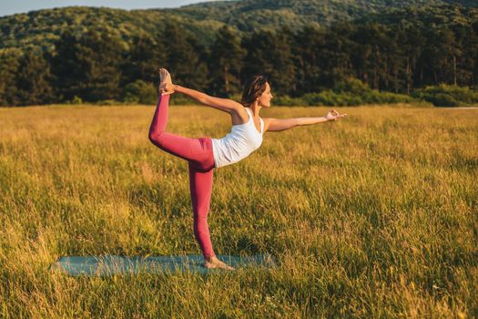 Beautiful woman doing yoga in the nature,Natarajasana / Shiva posture.