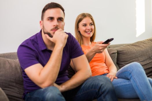 Angry wife and husband are having conflict because wife is watching tv too much.