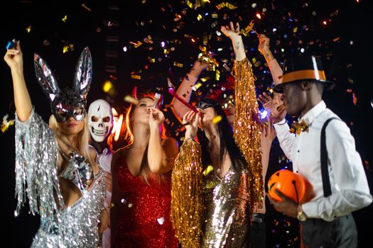 Happy people men and women mixed race dancing together on Halloween party