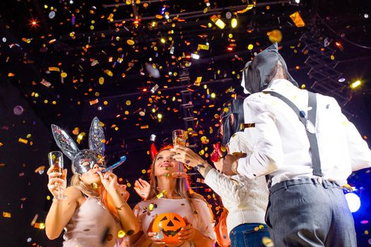 Happy people men and women mixed race dancing together on Halloween party