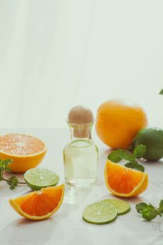 organic cosmetics with herbal extracts of lemon, orange, mint on bright background