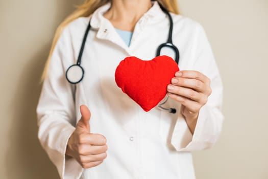 Image of female doctor showing heart and thumb up.