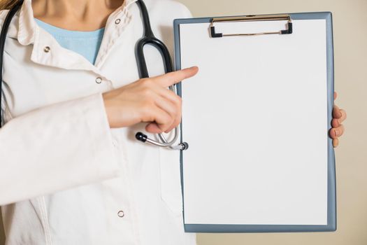 Image of female doctor showing on clipboard