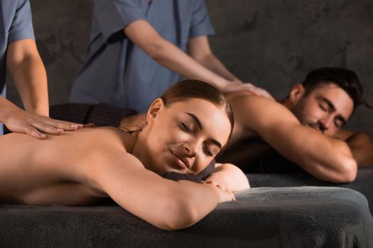 An attractive young couple lying on massage beds at a spa