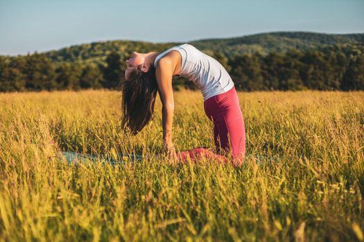 Beautiful woman doing yoga in the nature,Ustrasana/Camel pose