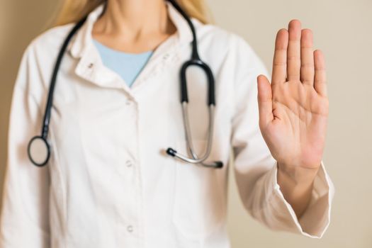 Image of female doctor showing stop sign.