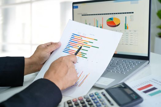 Asian accountant working and analyzing financial reports project accounting with laptop and calculator in modern office, finance and business concept.