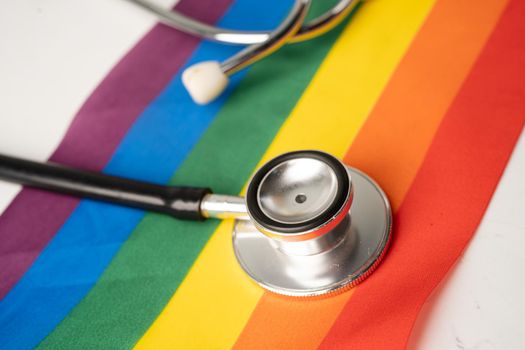 Black stethoscope on rainbow flag background, symbol of LGBT pride month celebrate annual in June social, symbol of gay, lesbian, bisexual, transgender, human rights and peace.