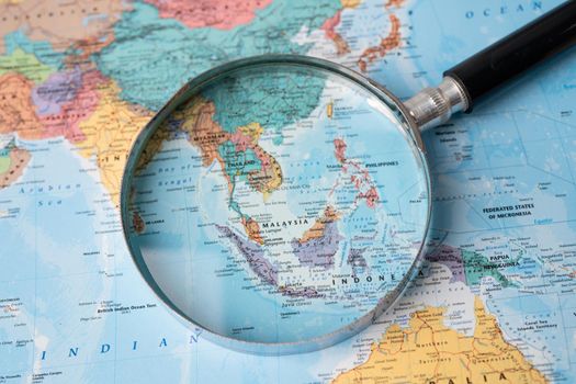 Bangkok, Thailand - August 01, 2020 Asia, Magnifying glass close up with colorful world map