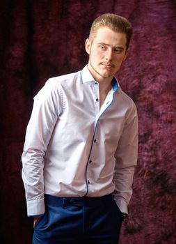 Portrait of a young man in a white shirt, with his hands in his Trouser pockets