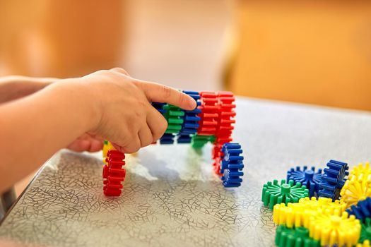 A boy collect a soft puzzle at the table. Preschool children and educational toys