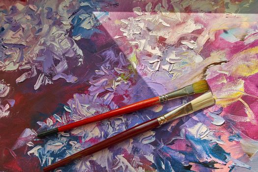 Brush on a painted abstract background.The top view. Tools for hobby or education. Arts.